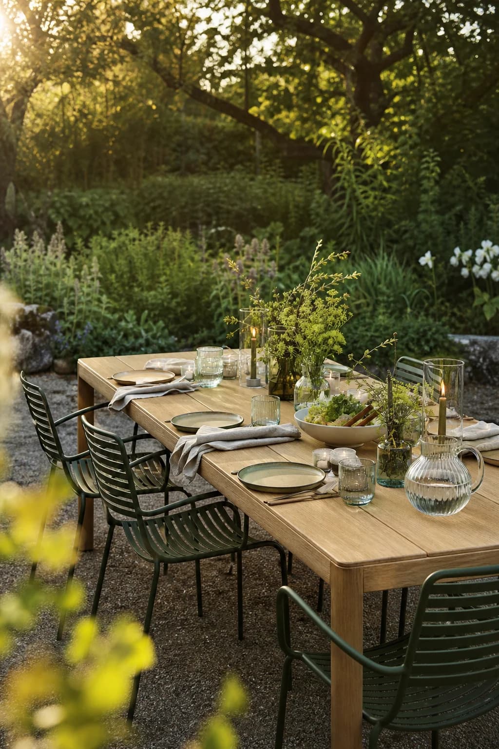 Outdoor dining table laid for an evening meal in a green garden